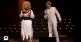 A still from a Channel 9 video of one of Wickety Wak impersonating Dolly Parton and Kenny Rogers.