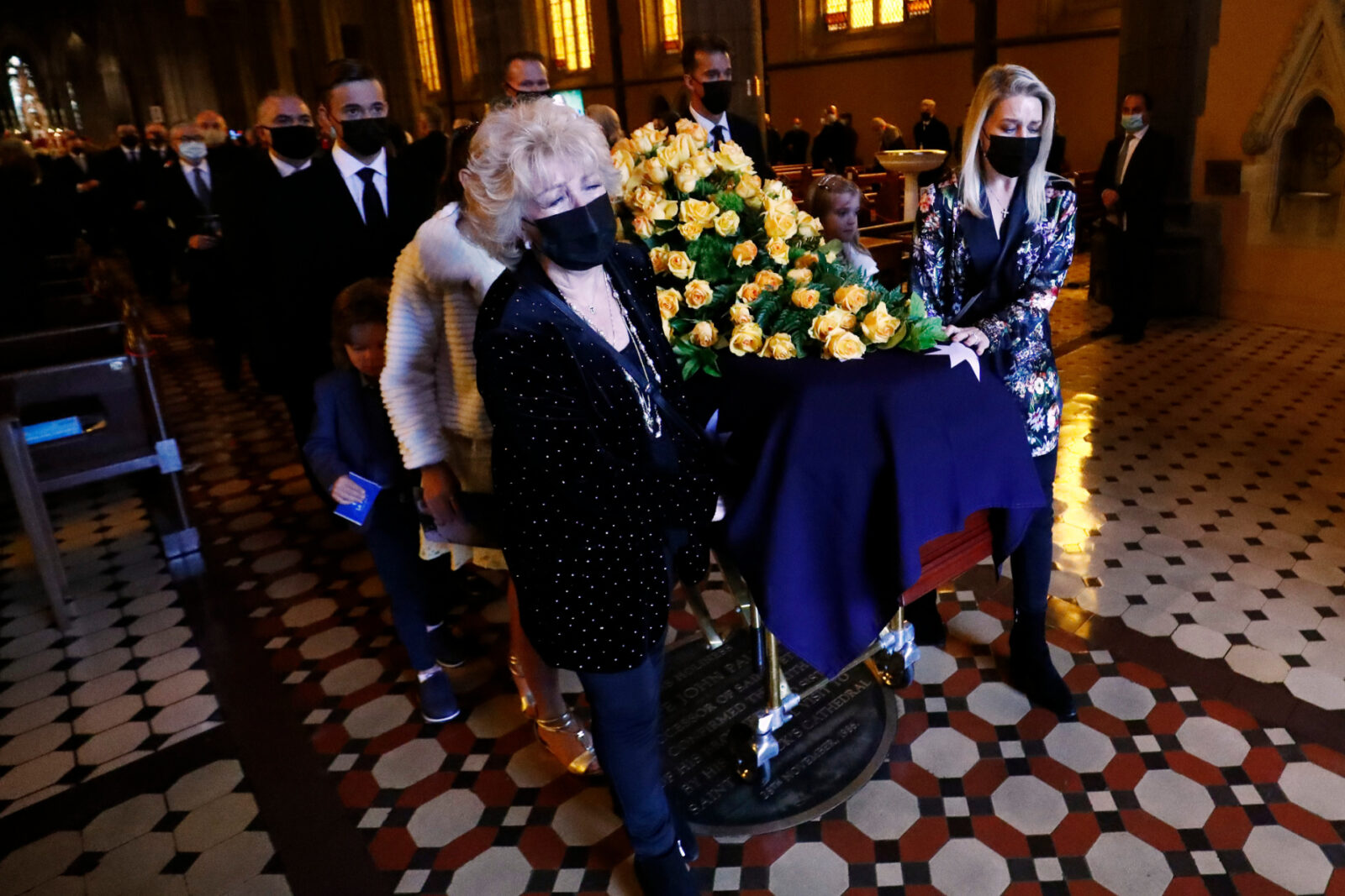 Patti Newton and family walking out beside coffin. Source: Getty